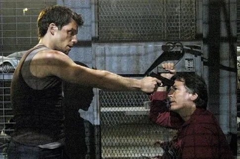 Samuel Anders apuntando con una pistola a un hombre en Battlestar Galactica