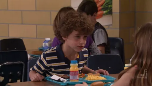 Un niño de pelo rizado en el comedor del colegio