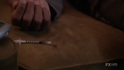 Una jeringuilla sobre una mesa en Damages