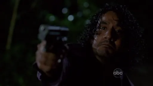 Sayid apuntando con una pistola de noche en Lost
