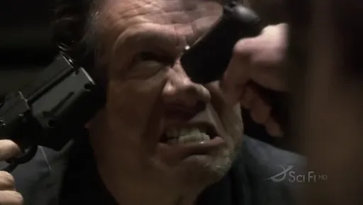 Saul Tigh con una pistola apuntándole a la cabeza en Battlestar Galactica
