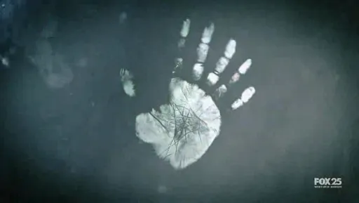 Una huella de mano blanca sobre un cristal en Fringe