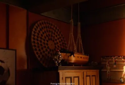 Una estancia con una maqueta de barco y un objeto circular en la pared