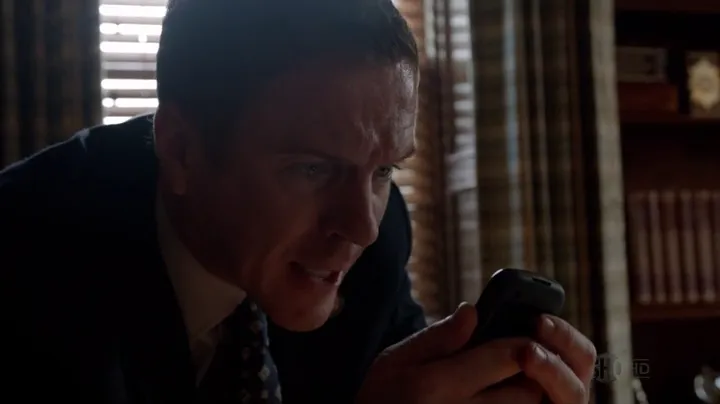 Nicholas Brody hablando por un móvil en la penumbra en Homeland