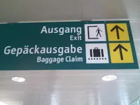 Cartel del aeropuerto que indica la salida y la recogida de equipajes